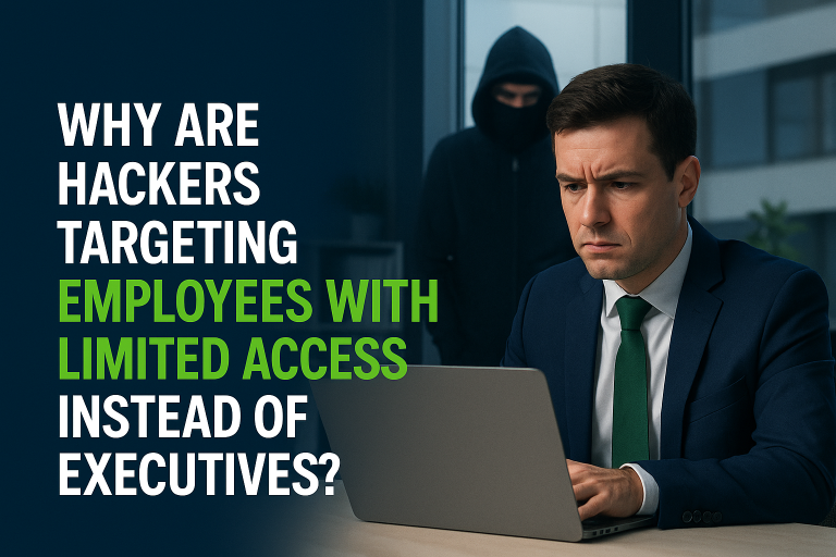 Businessman working on laptop with hooded hacker lurking in background, illustrating cybersecurity article about hackers targeting employees with limited access instead of executives